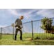 Man using STIHL FS 50 C-E to trim along fence line