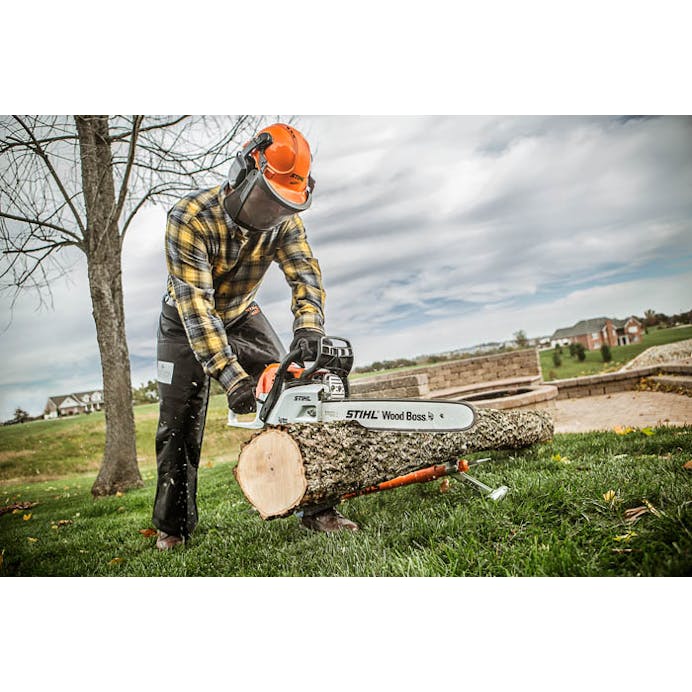 Man leaning down to cut log with the MS 251 WOOD BOSS®