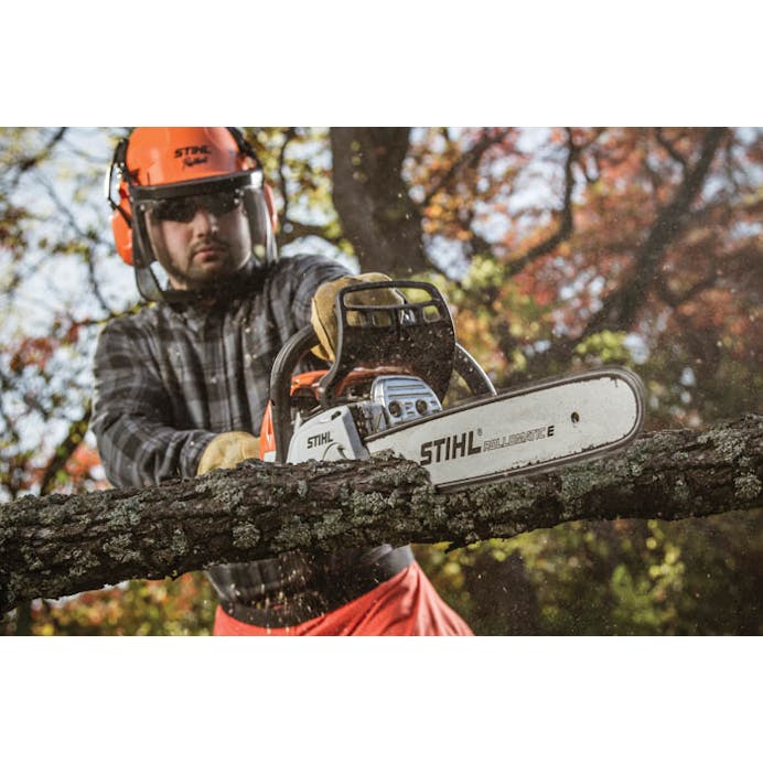 Man in protective wear using MS 251 C-BE Chainsaw to cut a branch