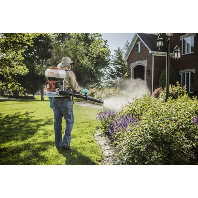 Man spraying garden on front lawn using the SR 200