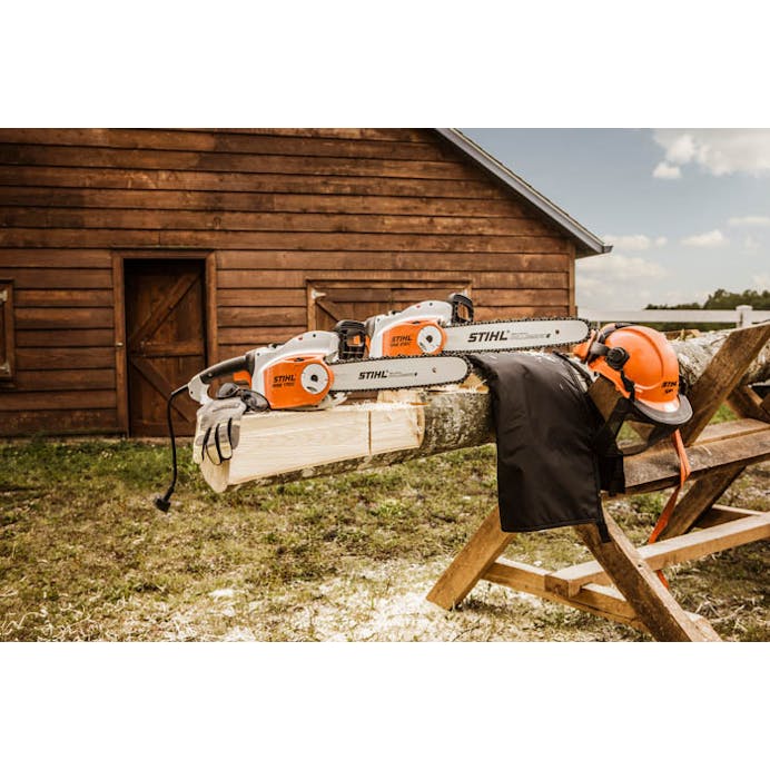 Two MSE 170 C-B chainsaws positioned atop logs with protective gear