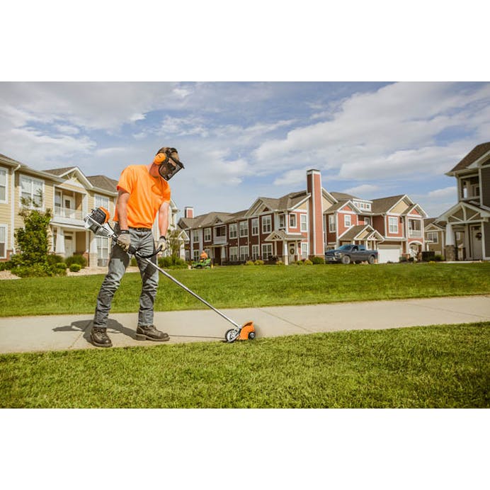 Man using FC 91 on edge of sidewalk in front of houses
