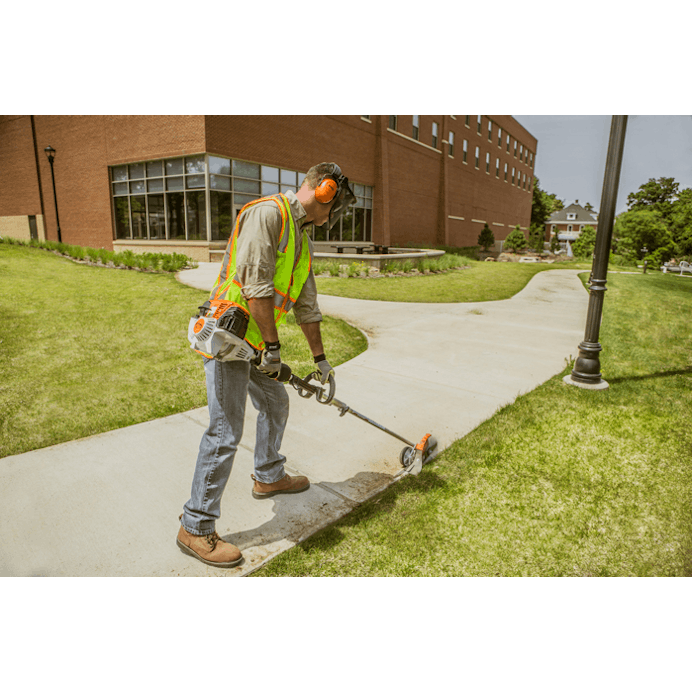 Man trimming grass on the edge of the sidewalk using the KM 111 R