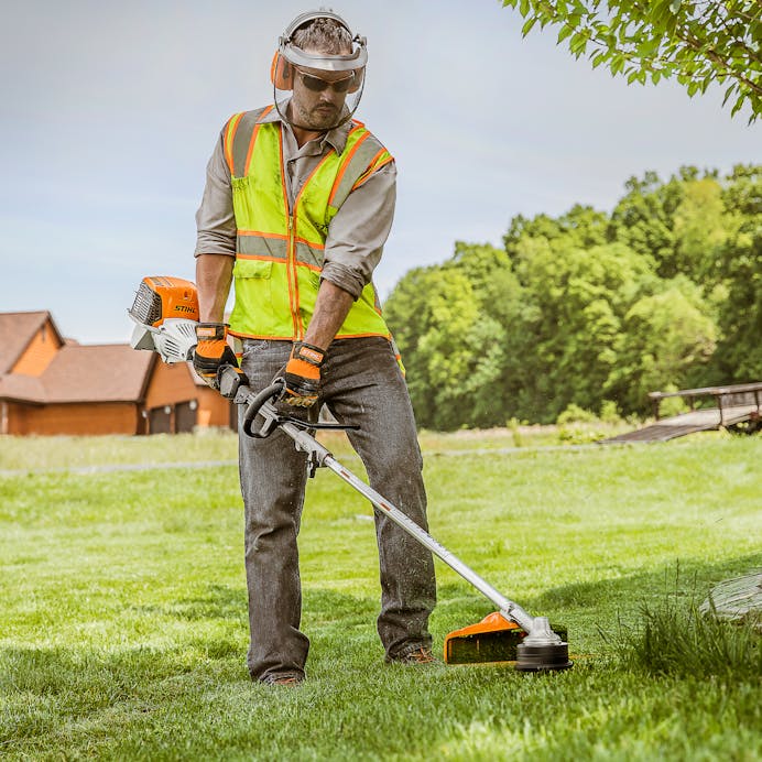 Man in STIHL protective gear trimming grass using the KM 91 R