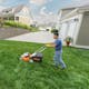 Man cutting backyard lawn with STIHL RMA 510