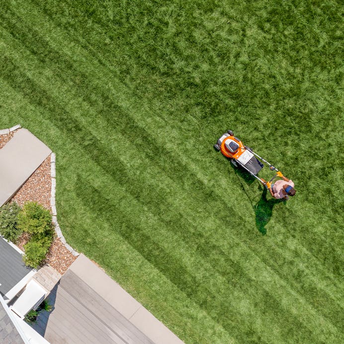 Aerial of man cutting lawn with STIHL RMA 510