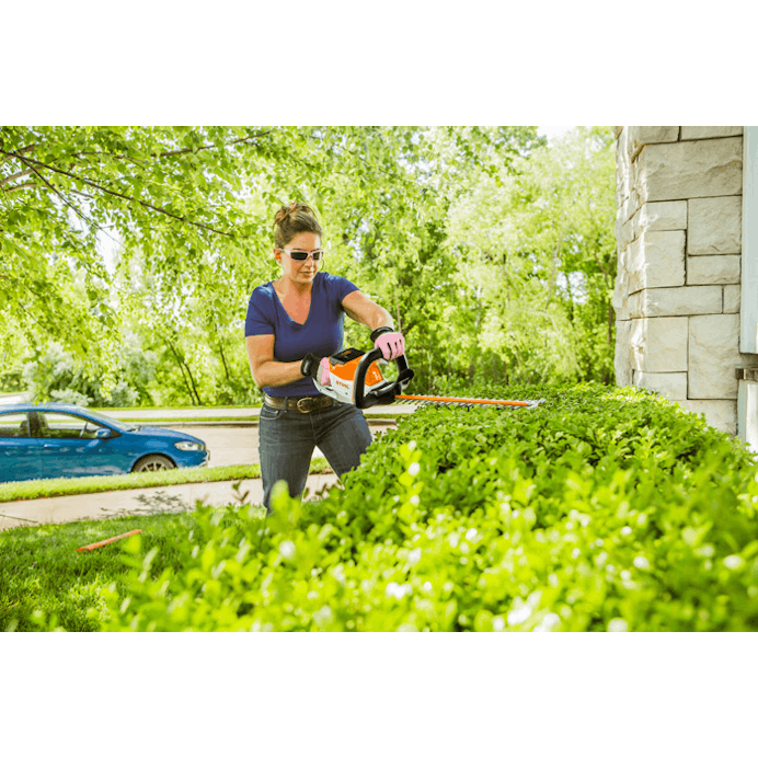 Woman trimming hedge using the STIHL HSA 56