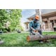 Man cutting log with MSA 120 chainsaw in backyard