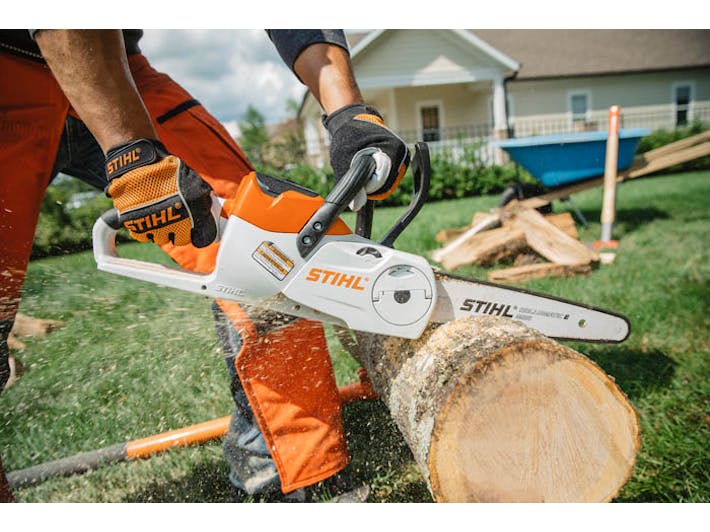 Man cutting log with close up of MSA 120 chainsaw side view
