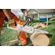 Man cutting log with close up of MSA 120 chainsaw side view