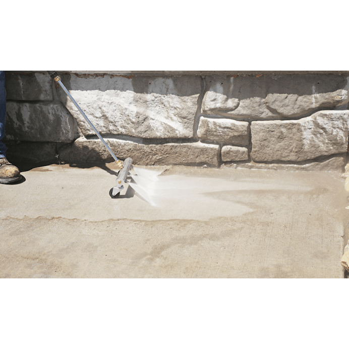 Close up of the water broom being used to clean off sidewalk