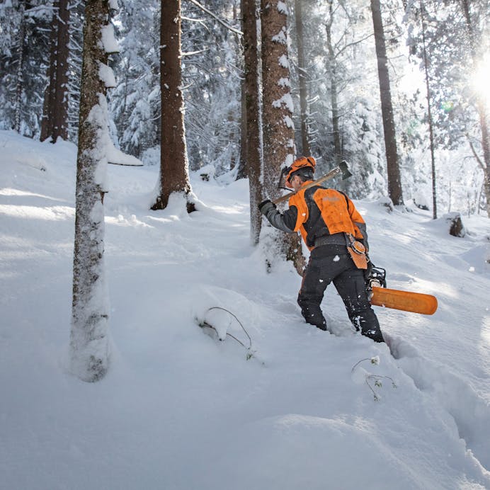 Man walking in snow holding MS 462 R C-M