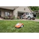 Man packing car while iMOW® RMI 422 PC-L mows the front yard 