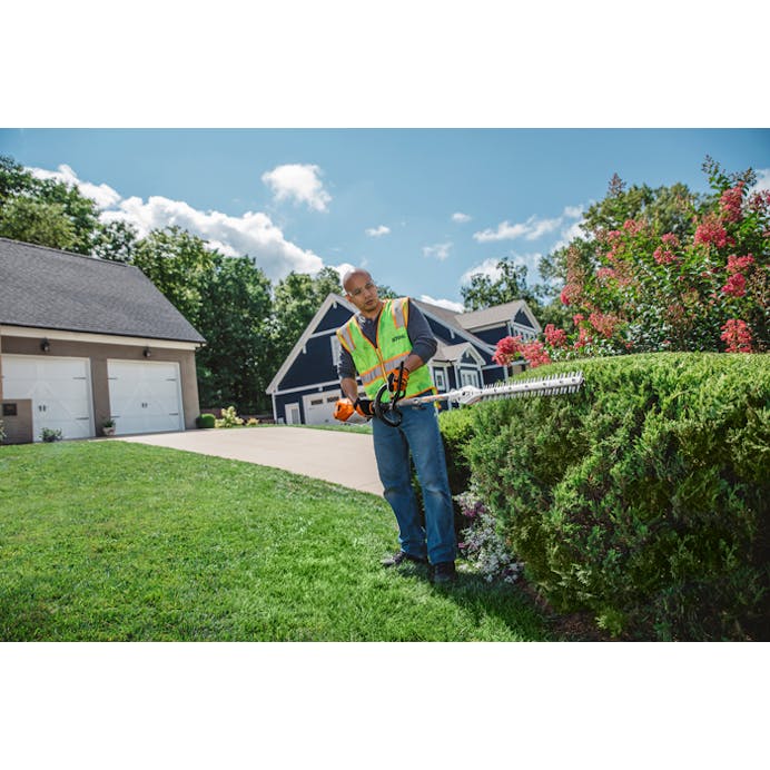 Man trimming hedge in font yard using the KMA 135 R