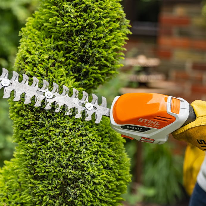 Close up of HSA 26 trimming hedge