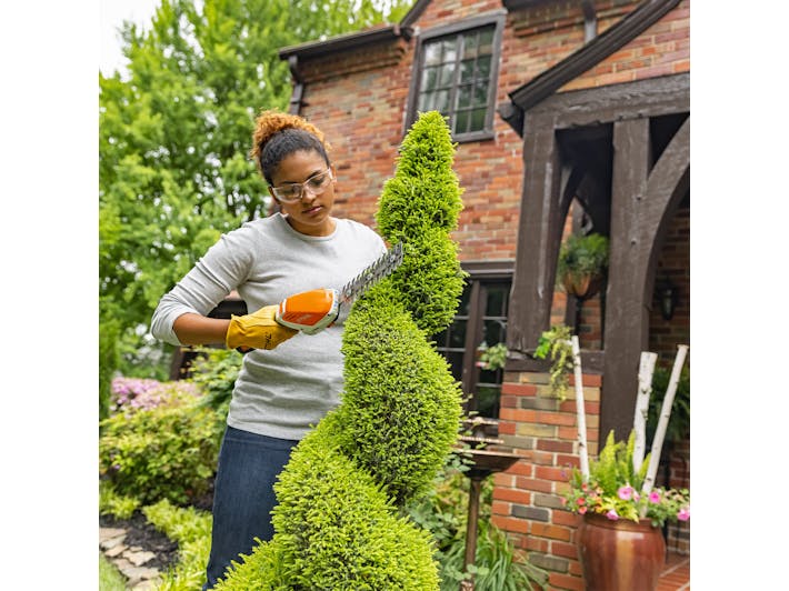 Woman trimming a hedge with HSA 26