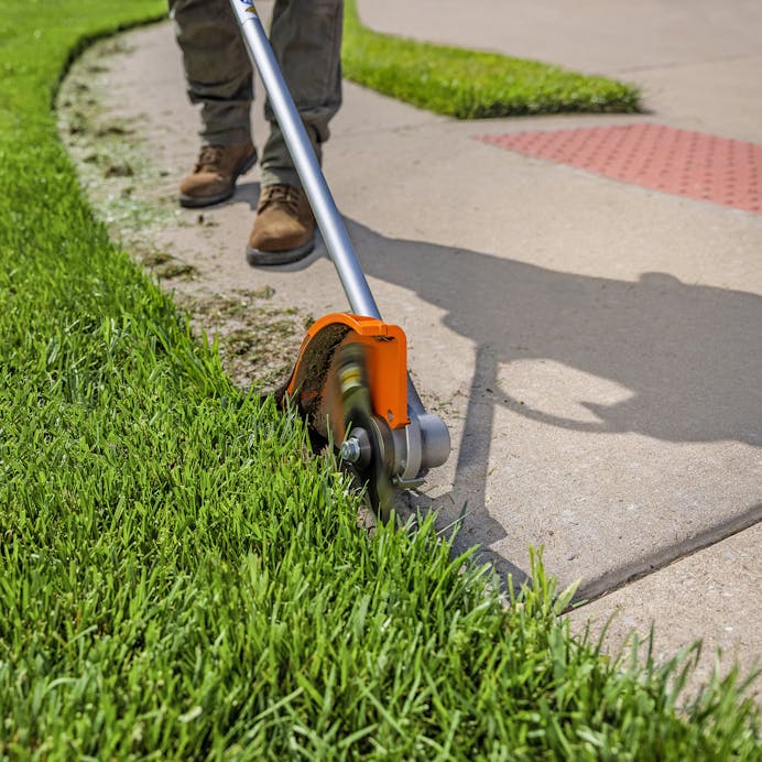 Close up shot of man trimming grass using FCA 140