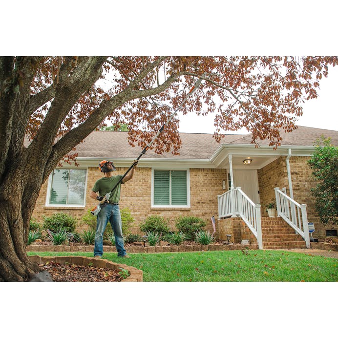 Man using the HTA 50 shaft extension to cut high branches on tree