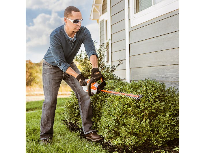 Man trimming hedges with HSA 40 in STIHL PPE