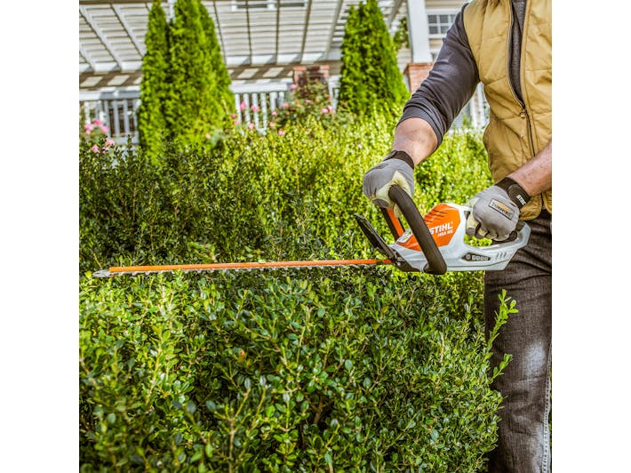Close up of man trimming hedges with HSA 40