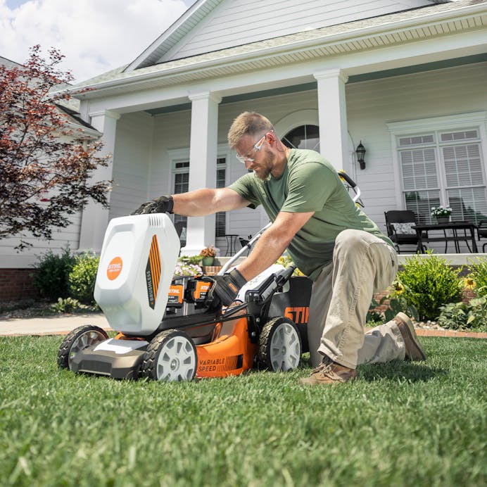 Man adding battery to the RMA 348 V in the yard