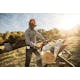 Man cutting a log with the MS 170 Chainsaw with the sun blazing in the background