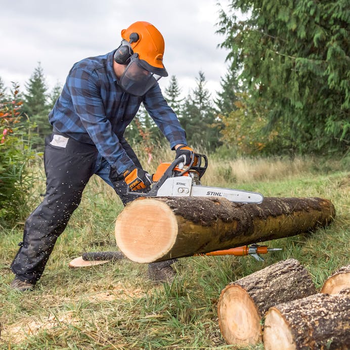 Man in protective gear cutting log with the MS 170