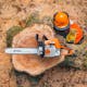 View from above of MS 250 Chainsaw resting on a tree stump next to some STIHL protective wear