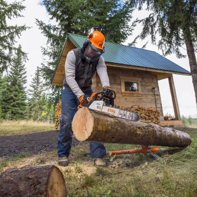 Man using MS 250 Chainsaw to cut log