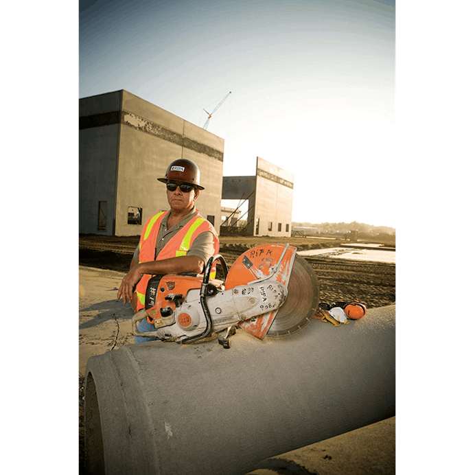 Man resting arm on TS 800 STIHL Cutquik® that is positioned atop a concrete pipe 
