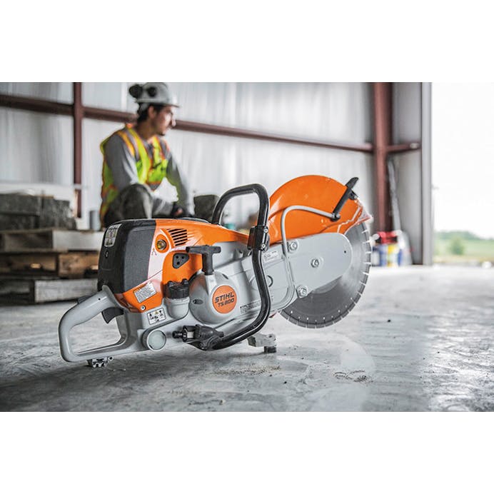 Man sitting on wood panels with the TS 800 STIHL Cutquik® on the floor in front of him