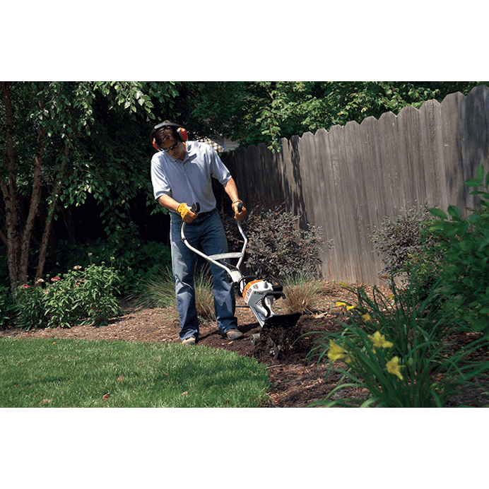 Man using the BF-MM Pick Tines Attachment to cultivate mulch 
