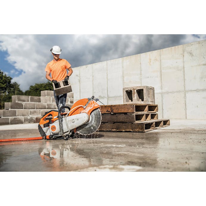 Side of view of the TS 420 STIHL Cutquik® resting on the concrete in front of man lifting concrete blocks
