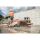 Side of view of the TS 420 STIHL Cutquik® resting on the concrete in front of man lifting concrete blocks