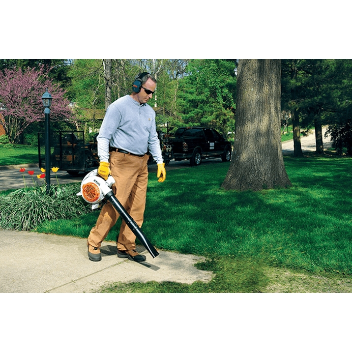 Man using BG 86 to blow grass clippings off driveway