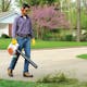 Man using BG 86 C-E to clear grass clippings from sidewalk