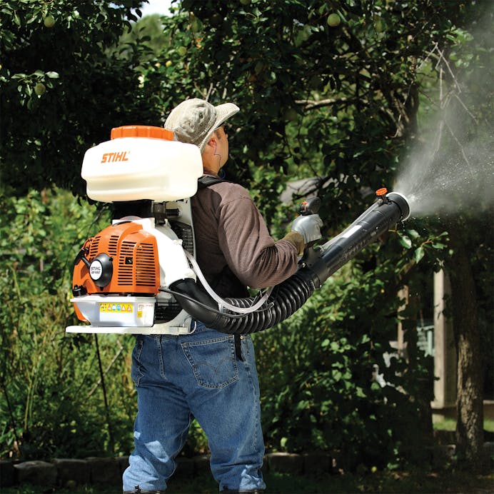 Man using the SR 450 to spray a tree