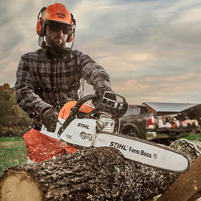 Man in protective gear cutting log with MS 271 FARM BOSS®